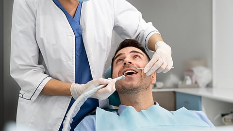A young man undergoing dental treatment in a dentist office.