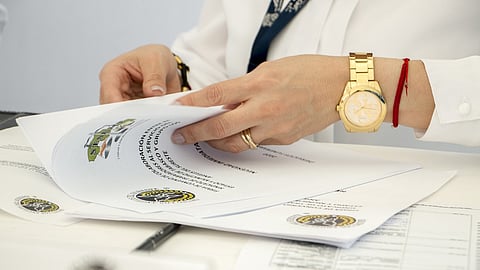 A person is checking few documents at a table.