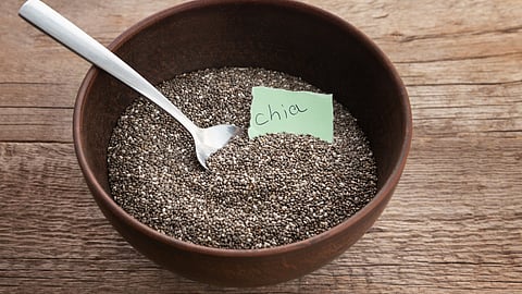 Nutritious chia seeds in a bowl on wooden background.