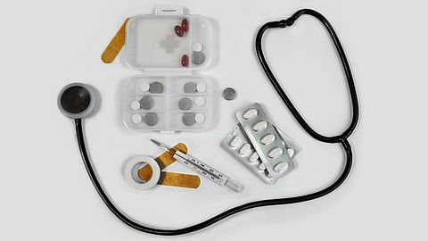 The image shows medical equipment, including a stethoscope, thermometer, and medications.