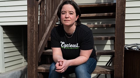 An image of Carmen wearing a black shirt sitting on stairs.