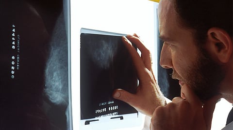 A doctor looking at X-rays that will help in screening and diagnosis.