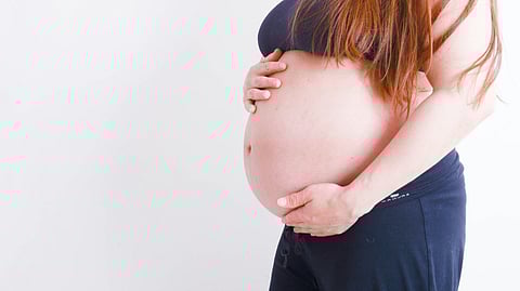 Pregnant lady touches her belly