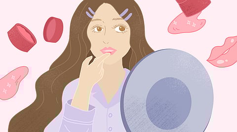 A lady applying lip balm in front of a mirror