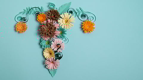 A flower arrangement using multiple types of flowers to form a female reproductive system with ovaries and uterus.