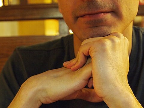 Close-up of a person interlocking their fingers, preparing to crack their knuckles.