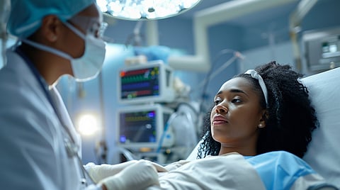 A black woman receiving treatment in an ICU.