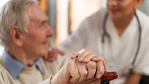 Casual senior man at home with doctor