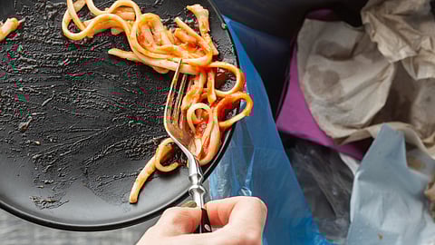 Leftover wasted spaghetti pasta thrown in a bin