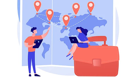 A couple marking locations on a world map and noting down something in their laptops.