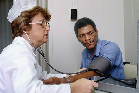 A nurse checks blood pressure of a patient at a clinic