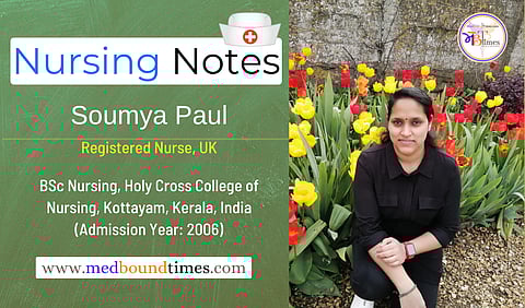 An image of Soumya posing near a bed of yellow and red tulips in a black outfit.