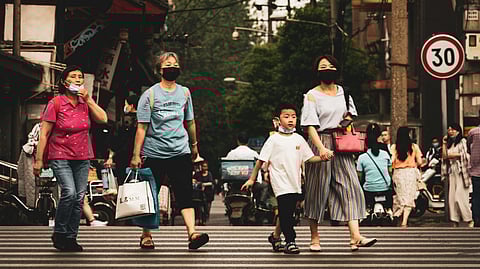 People wearing masks walking on a road