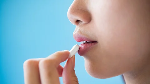 Young woman taking medicine pill after doctor order