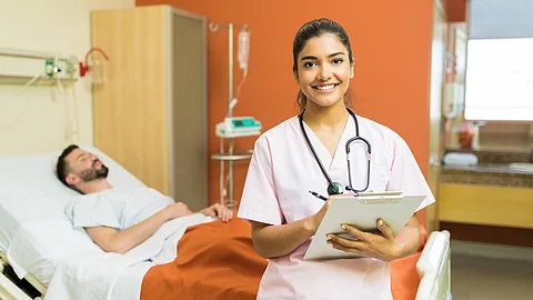 A female doctor with reports on a clipboard standing against a male patient at a hospital