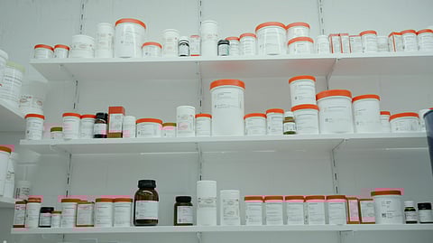 A shelf filled with various bottles and jars, showcasing a range of colors and sizes.