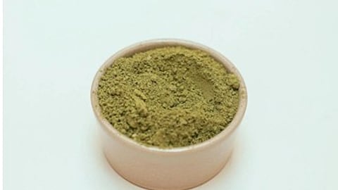 A green powder in a cream color bowl.
