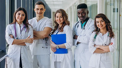 A team of five doctors standing together, representing doctors from different specialties.