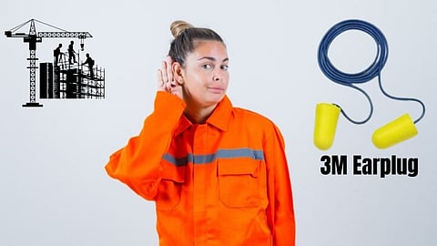 A construction worker in orange uniform, an ear plug and ongoing construction behind.