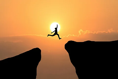 Courage man jump through the gap between hill