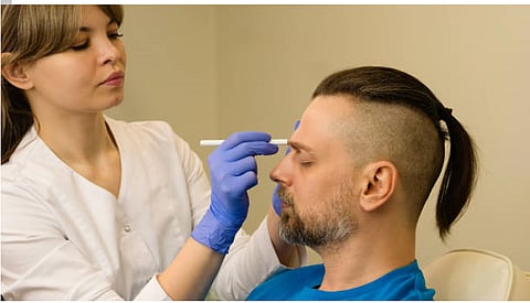 A professional taking some measurements from face during a clinical appointment.