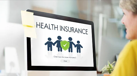A senior citizen viewing about Health insurance on a screen.