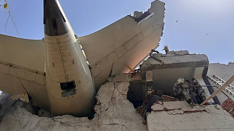 A tail of an airplane stuck in a building.
