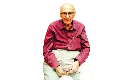 Dr. Mahinder Watsa wearing a maroon shirt and faded white pants.