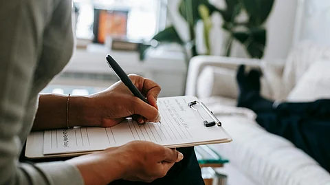 A woman is noting down something on a notepad.
