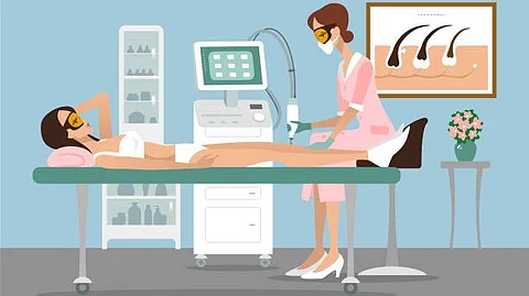 A woman receiving a laser hair removal treatment from a technician in a clinic.