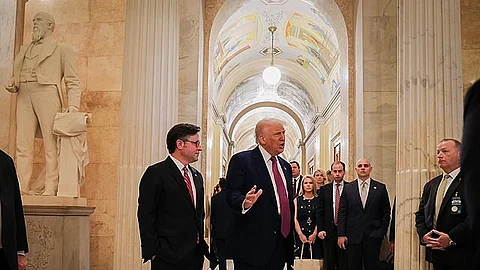 President Donald Trump is speaking to few other people in a hallway of Capitol.