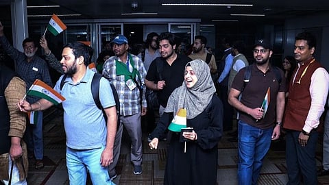 Indian students on airport carrying Indian flags while coming from Iran.