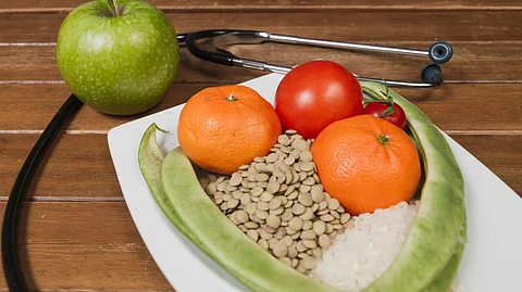 A stethoscope is wrapped around a healthy meal.