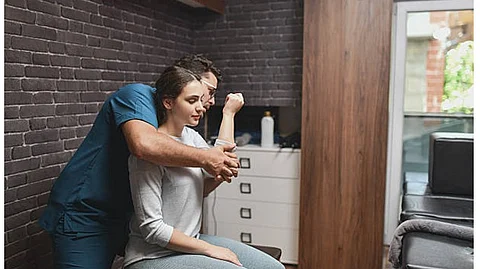 A chiropractic is helping a woman stretch her left arm.