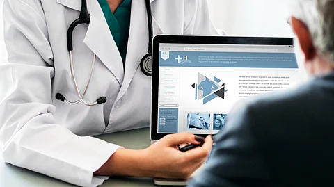 A doctor explaining something to a patient in a laptop.