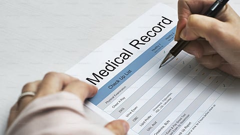 A person filling out medical record form.