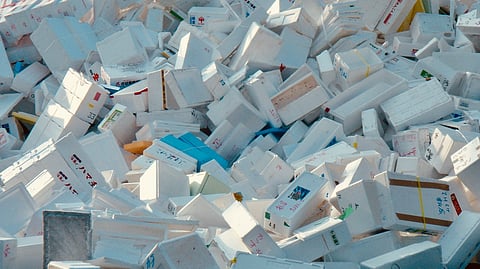 A stack of white medicine boxes is arranged haphazardly on a flat surface.