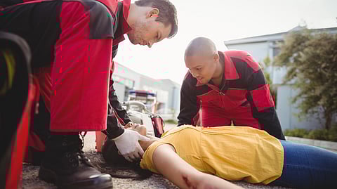 An injured woman is being examined by 2 paramedics.