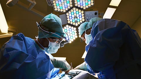The image shows two surgeons working keenly in operation theater.