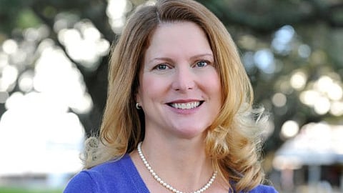 Dr. Christina B. Propst, wearing a blue dress and pearl necklace