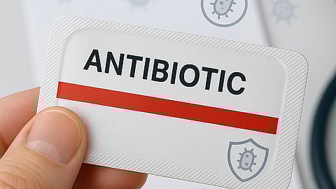 Image of a hand holding an antibiotic strip a bold red line.
