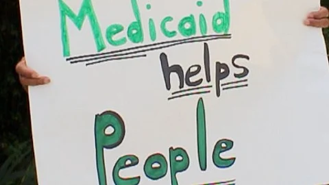Placard saying "Medicaid helps people."