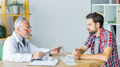 The image shows a patient discussing with a doctor.