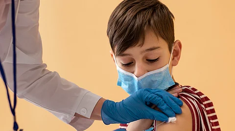 The image a health worker injecting vaccine to a child.