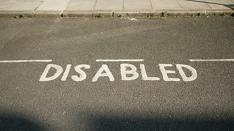 The word ‘DISABLED’ painted on road for designated parking space for disabled people.