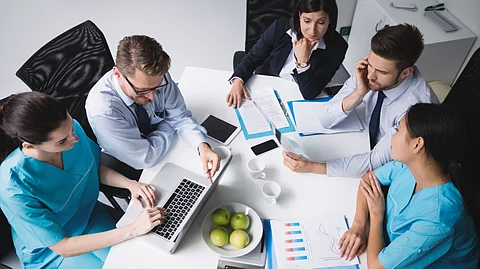 Five people around a table during a discussion.