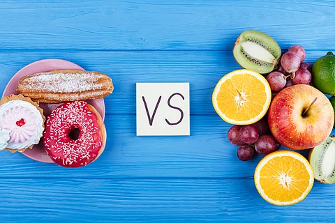 Visual comparison of unhealthy processed foods vs. fresh fruits, symbolising the impact of food cuts on healthy eating.