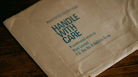 A white envelope labeled "Handle with Care," emphasizing the importance of careful handling.