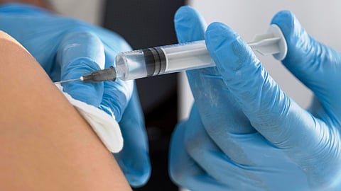 A close-up of a person getting an injection on their upper arm.
