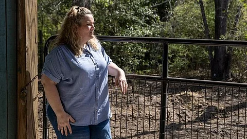 Erin Schaeffer standing besides her home.